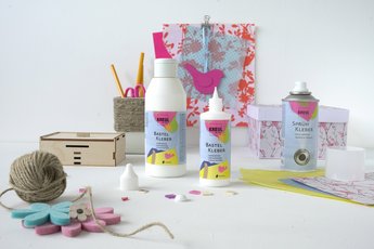 Flaschen KREUL Bastelkleber stehen vor Bastelmaterialien 