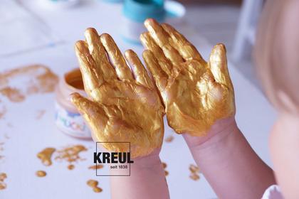 Fingerfarbe MUCKI ohne Chaos Tipps zum Malen mit kleinen Kindern Kinderhände mit goldener Fingerfarbe von MUCKI
