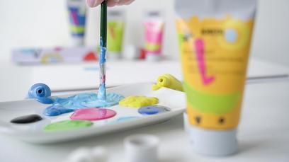 Fünf Fragen häufige Kids Art Künstlerfarbe Kinder KREUL Malfarbe Tutorial Anwendung Tipps Tricks FAQ KREUL Kids Art Kinder Künstlerfarbe Tube mit Palette und Pinsel beim Mischen